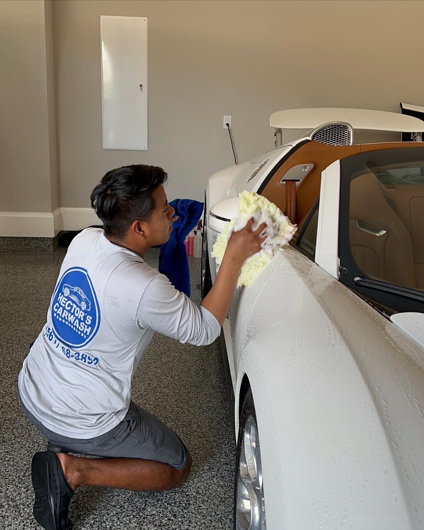 Hector hand-drying a car at the shop